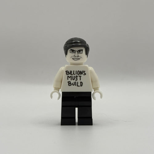 A custom-built toy minifigure resembling a LEGO figure, featuring a white torso printed with the text 'BILLIONS MUST BUILD' in black, black hair, and black legs, set against a plain light gray background.