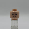 A small plastic toy head with a printed face, mounted on a clear stand against a plain light gray background.
