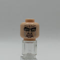 A custom printed LEGO minifigure head with a black face design, displayed on a clear plastic stand against a neutral gray background.