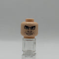 A custom-painted LEGO minifigure head with a drawn angry face and glasses, mounted on a clear plastic display stand against a neutral gray background.